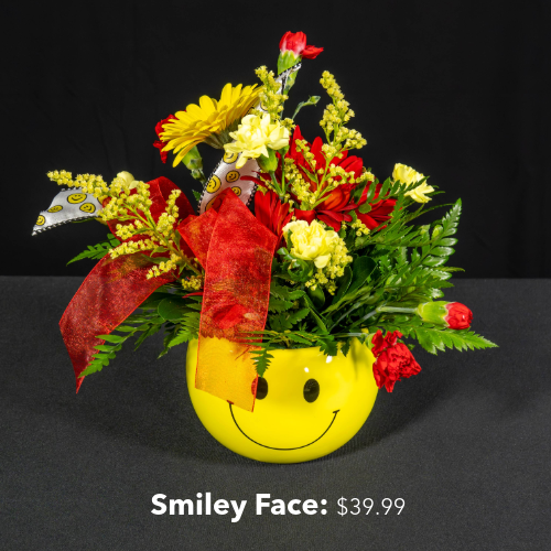 Flower arrangement in a smiley face mug. Arrangement is priced at $39.99
