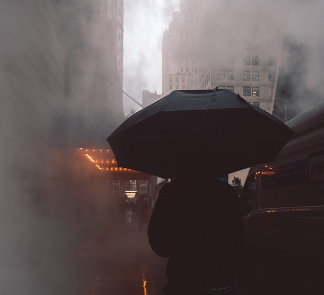 person on a foggy street with an umbrella